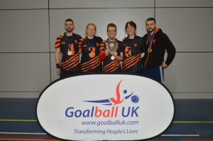 Dom Roper in a group Fen Tigers photo in front of a Goalball UK banner.
