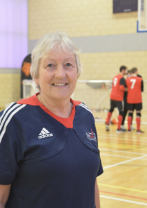 Image shows Judith stood wearing her Goalball UK t-shirt smiling at the camera