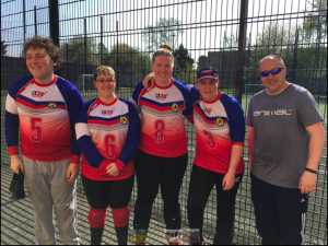Reanne Racktoo stood in a group photo of an RNC goalball team at a tournament.