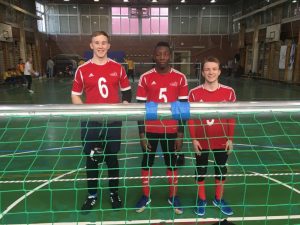 Team photo of GB men behind a goalball goal