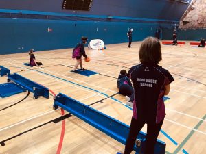 Action shot from Goalball UK School session in London, with goal judge in foreground