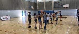 Group of school children playing 'over and under', with eyeshades, at school transition event