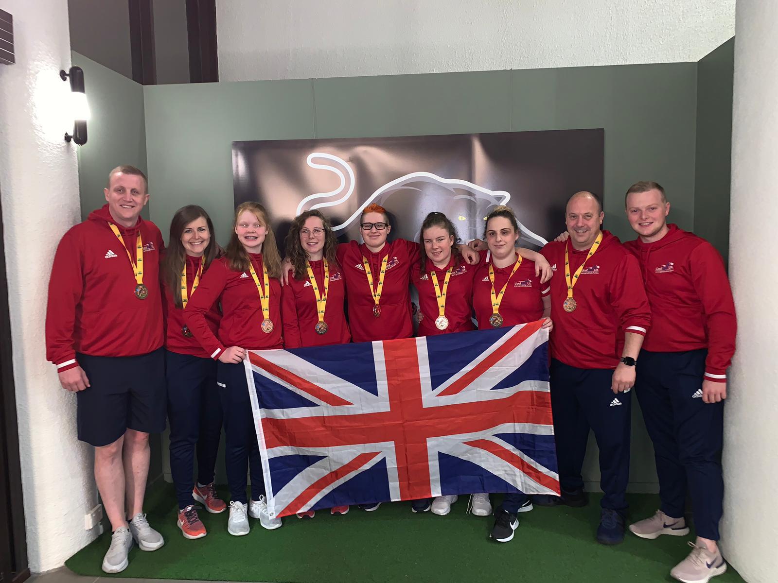 Group photo of GB Women under 19s with their bronze medals and holding the Union Flag