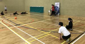 Action shot, with players on court, at a school goalball competition.