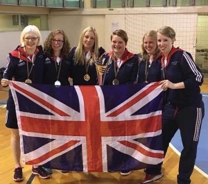 Women's Squad holding the Union Flag and wearing their gold medals.