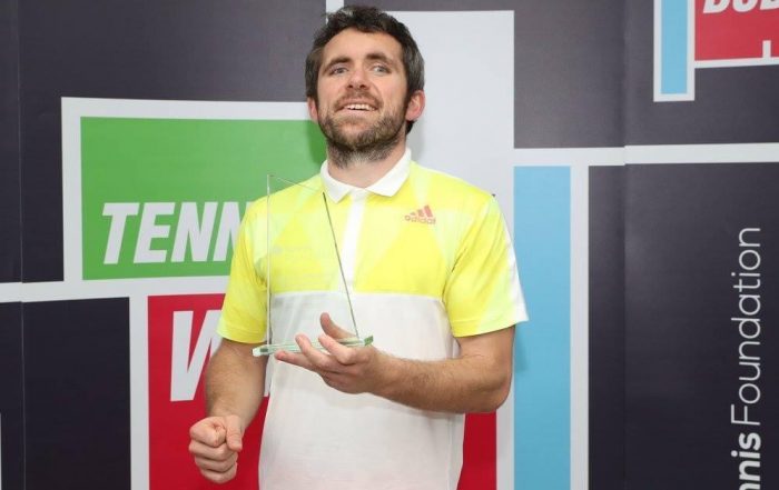 Image shows Roy smiling after receiving a tennis award