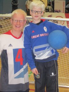 Image is of two goalball players in team GB kits posing for the camera