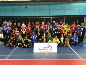 Group photo of the goalball family behind a Goalball UK banner