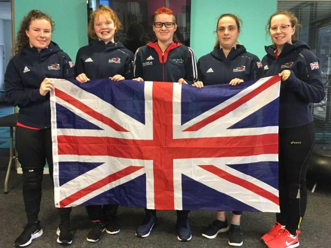 Image shows Megan stood with her GB teammates holding the Union Jack flag