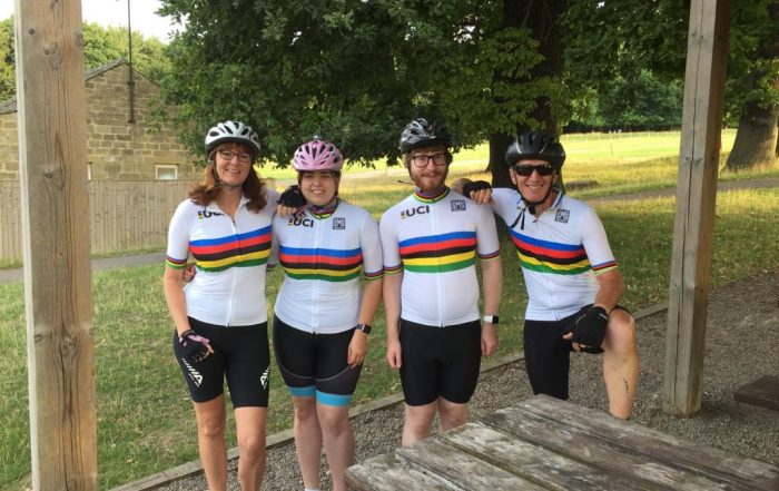 Image shows Brittany and fellow goalballer Diarmuid stood in their cycling attire with theirs guides