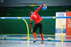 Caleb Nanevie playing for Great Britain in an international tournament. Caleb is about to throw the goalball.