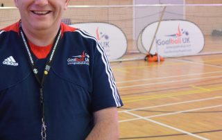 Smiley photo of Robert Avery in front of a goalball goal at The Factory Community Centre, Birmingham