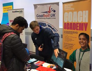 Alex Cockerham, at the time a Goalball UK activator, showing an interested student all things goalball.