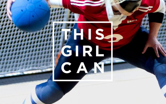 This girl can advertisement. It shows a female goalball player just about to shoot with the this girl can logo in front of her.