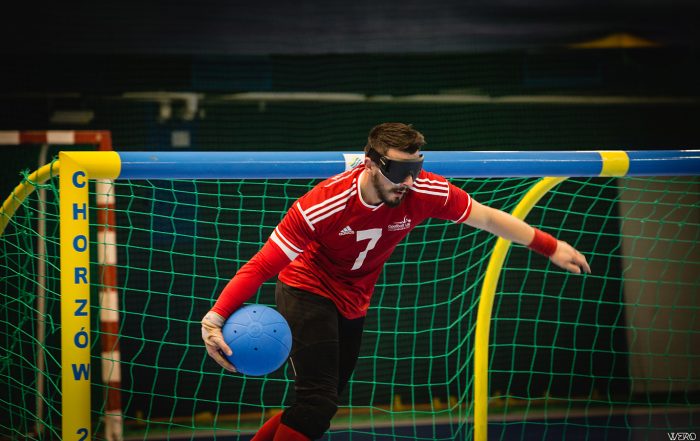 Dan Roper preparing to shoot for GB in an international tournament wearing a red GB top.