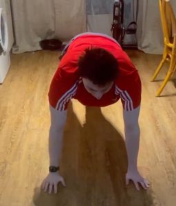 Josh Murphy demonstrating a standard press up position with his arms shoulder width apart.