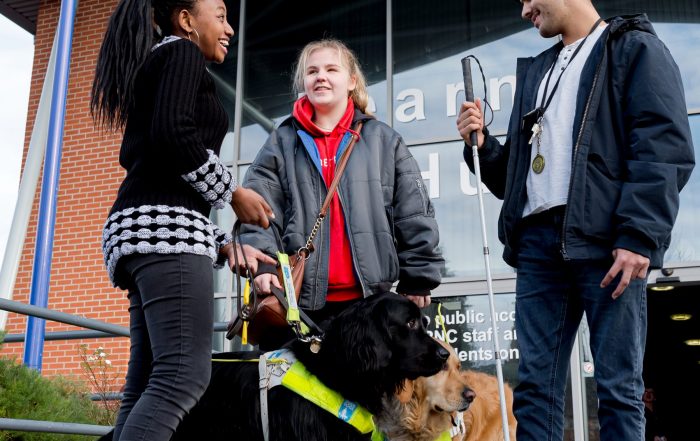 3 visually impaired students stood chatting outside RNC