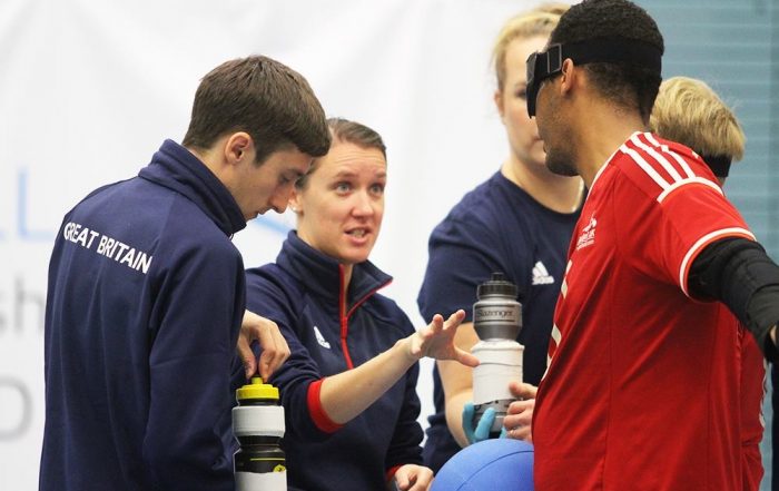 Faye Dale providing feedback to a GB player at a tournament.
