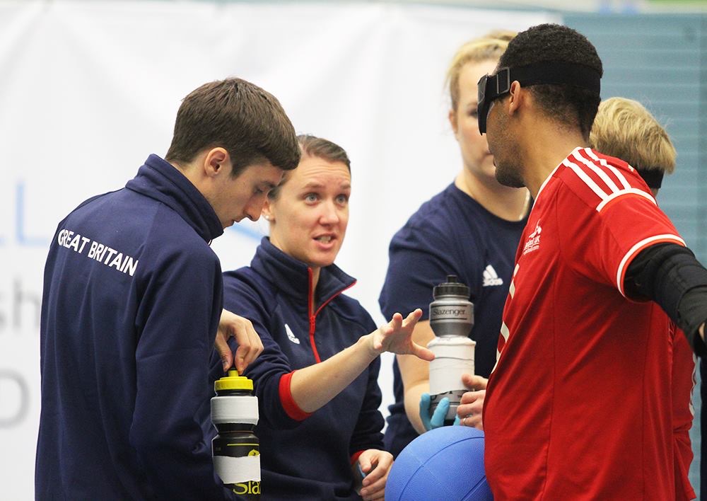 Faye Dale providing feedback to a GB player at a tournament.