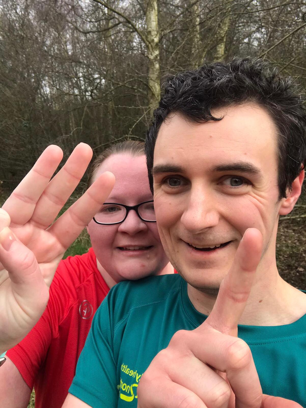 Anthony and Loren with their fingers representing 3.1 miles (5k)