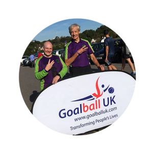 Tommy Britton and Robyn Faulkner standing behind a goalball banner