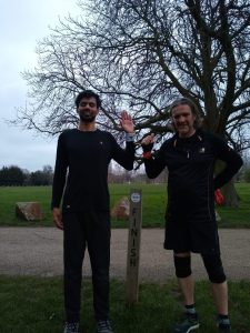 Naqi and his guide runner stood at the 5k finish line in the park