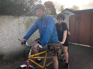 Sam and her dad on a tandem bike