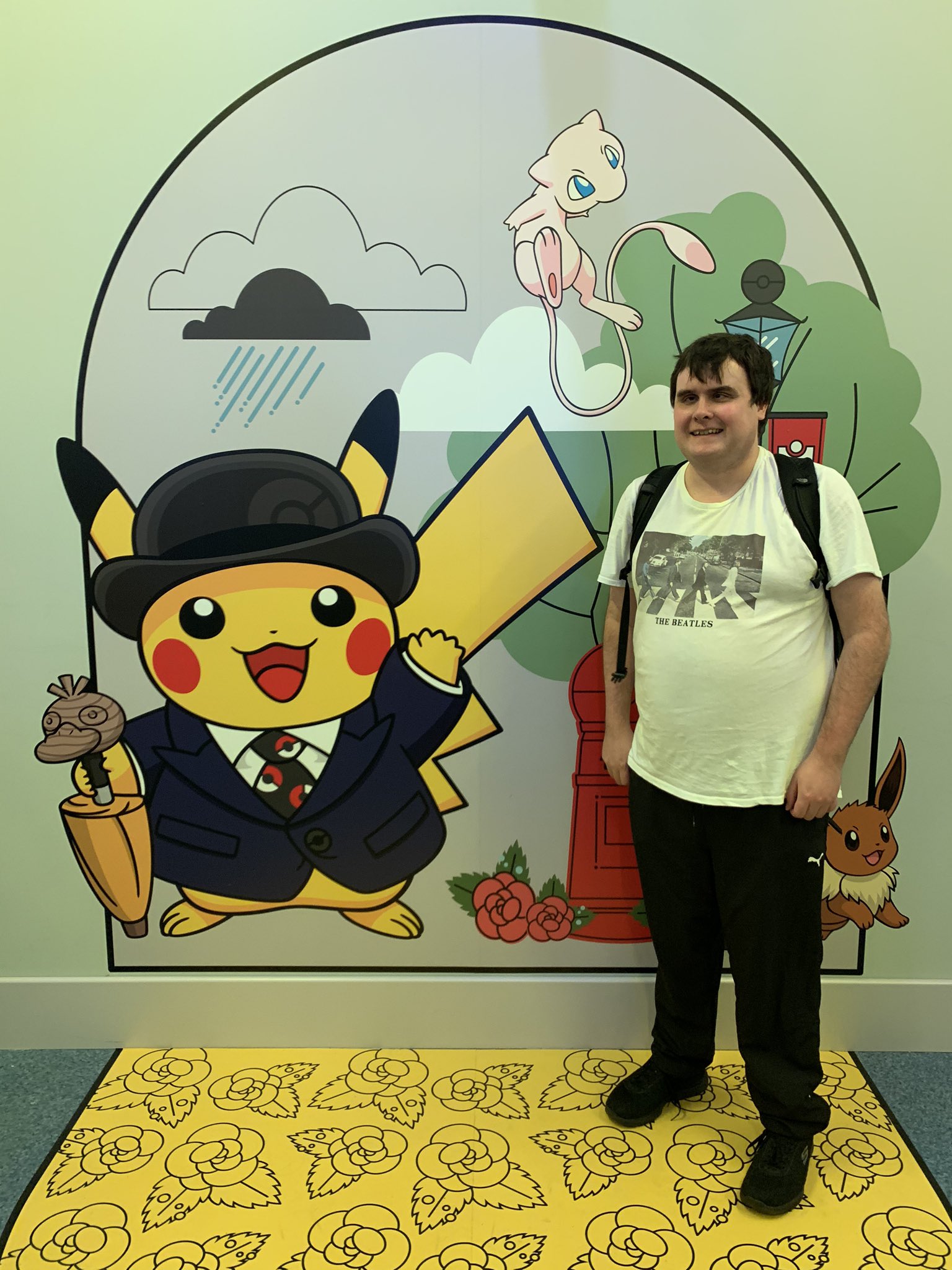 Image shows Graham Bowe stood next to a Pikachu graphic at the pokemon centre
