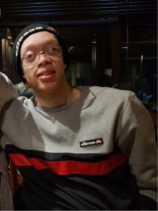 Image of Terrelle looking at the camera wearing a beanie