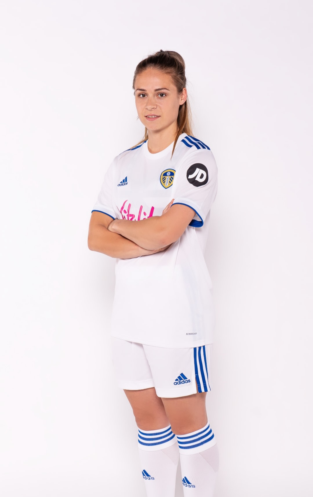 Josie Hewson stood with her arms folded in her Leeds United football kit, very professional.