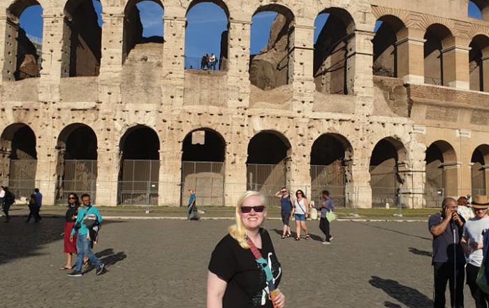 Sammie Korosi in front of the Colosseum in Rome, Italy on a very sunny day!