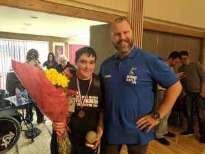 Reanne Racktoo of Blackburn Goalball Club stood with flowers and a referee after the 2018 Britains Disabled Strongman competition finishing 2nd!