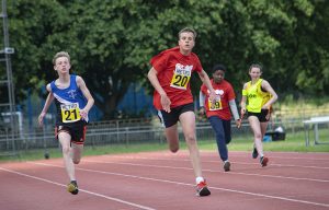 Arthur Milles sprinting at a Metro Blind Sport athletics event. In the image, he is in first place!