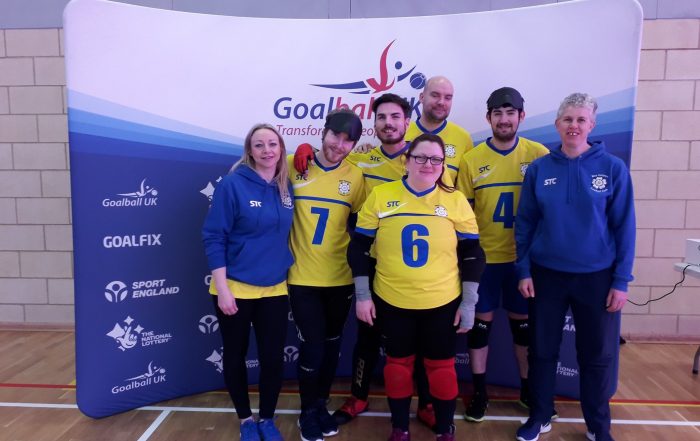West Yorkshire team photo at the 2020 Intermediate Finals. The team are wearing their yellow 'home' kit with coaches Kelly and Kathryn either side of the team.