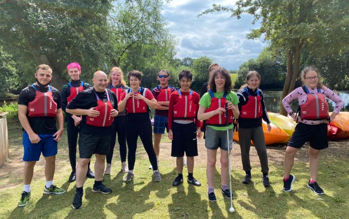 The team stood together at the National Water Sports Centre wearing life jackets and smiling before going into canoes!