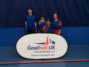 South Wales group photo wearing blue vests over playing tops behind a Goalbll UK banner.