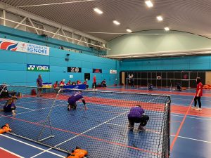 Picture taken behind the goal of Scarborough Panthers in purple jerseys against Mersey Sharks on the other side of the court.
