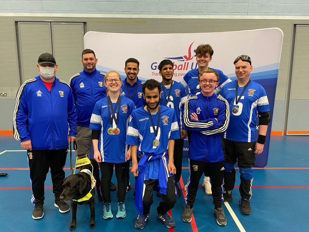 Birmingham group photo featuring players and coaching contingent with their medals. Guide dog is at the front and centre!
