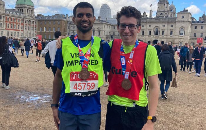Naqi stood with his guide runner after the race. They are both wearing their medals.