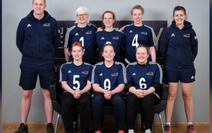 GB Women's team group photo with three players sat together at the front and three players stood behind them. Two coaches are stood either side.