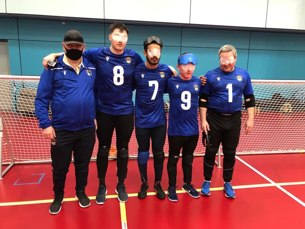 Birmingham Goalball Club standing together before a game linking arms.