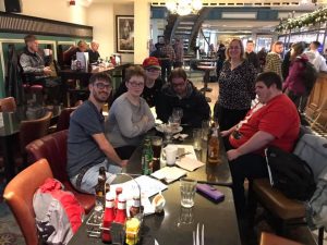 South Wales goalball social at a pub with people sat around a table with people in the background.