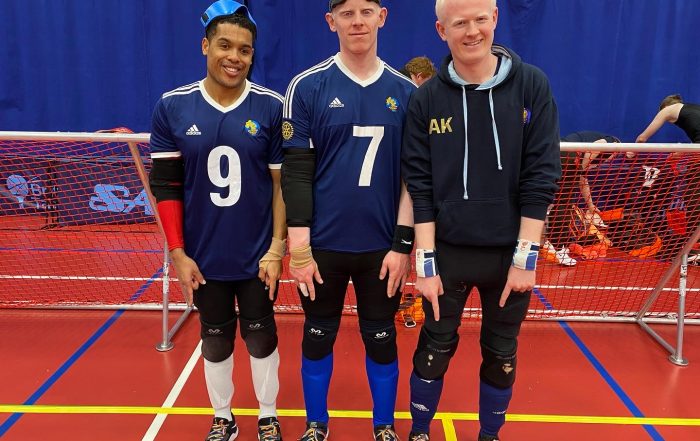 Winchester team standing on court pointing to their rainbow laces.