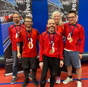 Lancashire Lions novice team wearing their gold medals in front of two Goalball UK banners.