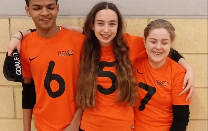 New College Worcester group photo with Rico, Ciara, and Phoebe standing together with arms around one another.