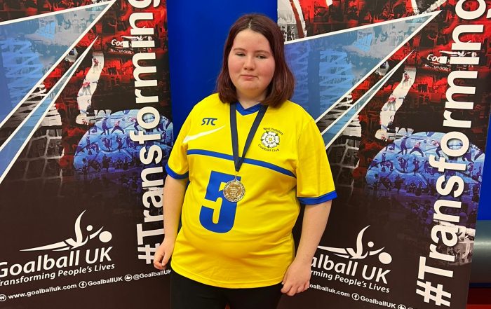 Ashleigh standing with her medal in her lucky number 5 yellow jersey!