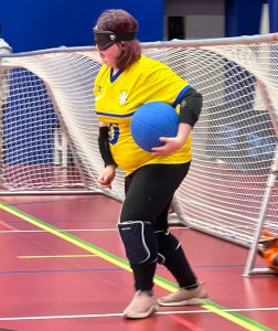 Ashleigh preparing to shoot a goalball rocket down court, just setting off from the goal line.
