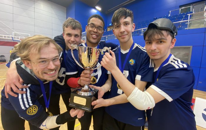 Winchester Intermediate Trophy team huddled together holding their newly won Intermediate Trophy!