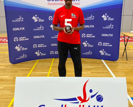 Yahye Siyad wearing his London Elephants jersey holding his Intermediate Trophy top goalscorer trophy!