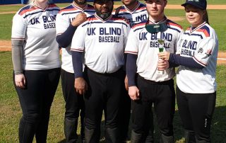 UK Blind Baseball team photo whilst on a baseball pitch at an international competition. The 6 players are all stood with each other posing for the photo!